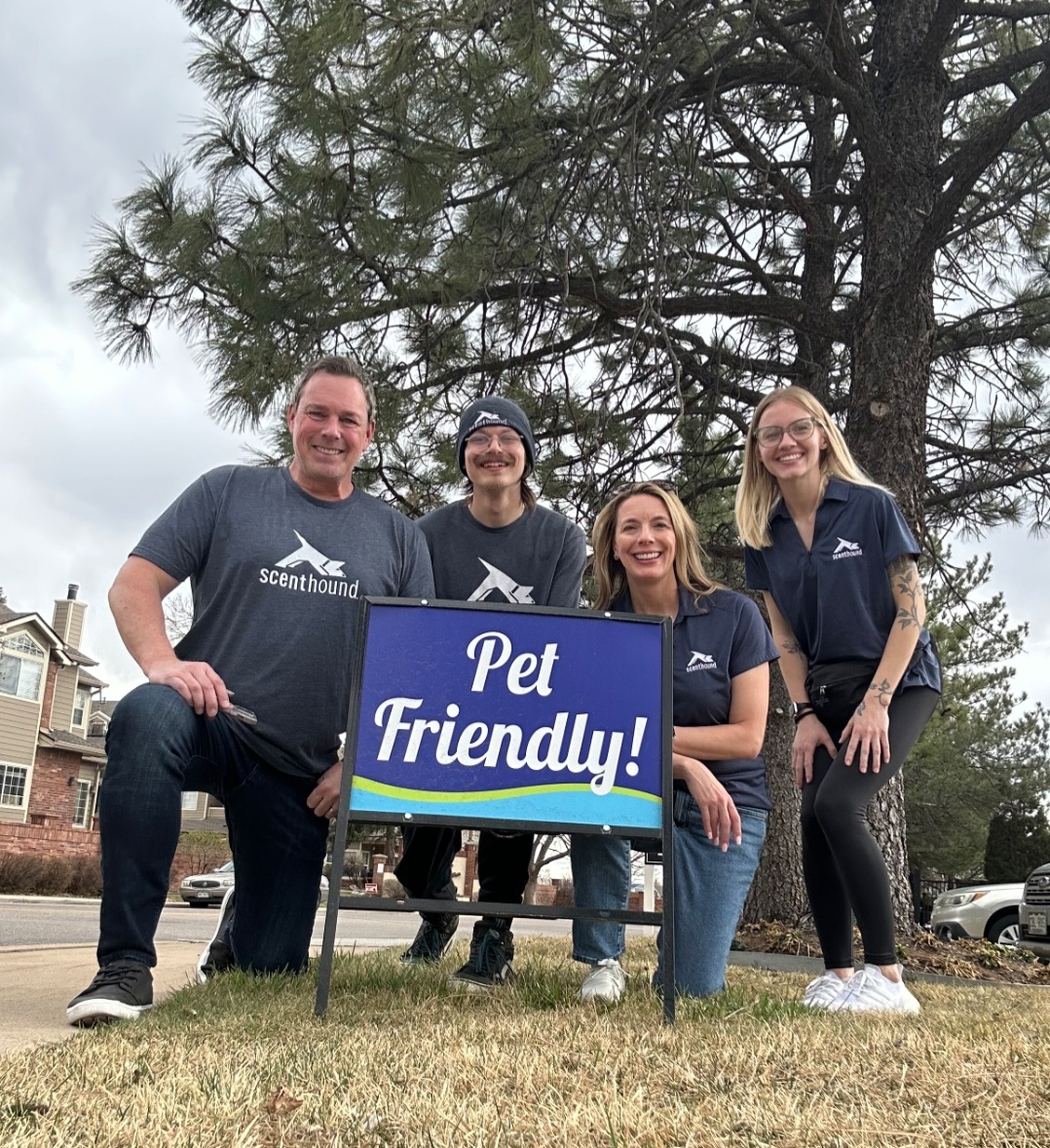 Scenthound team beside a Pet Friendly yard sign in a neighborhood