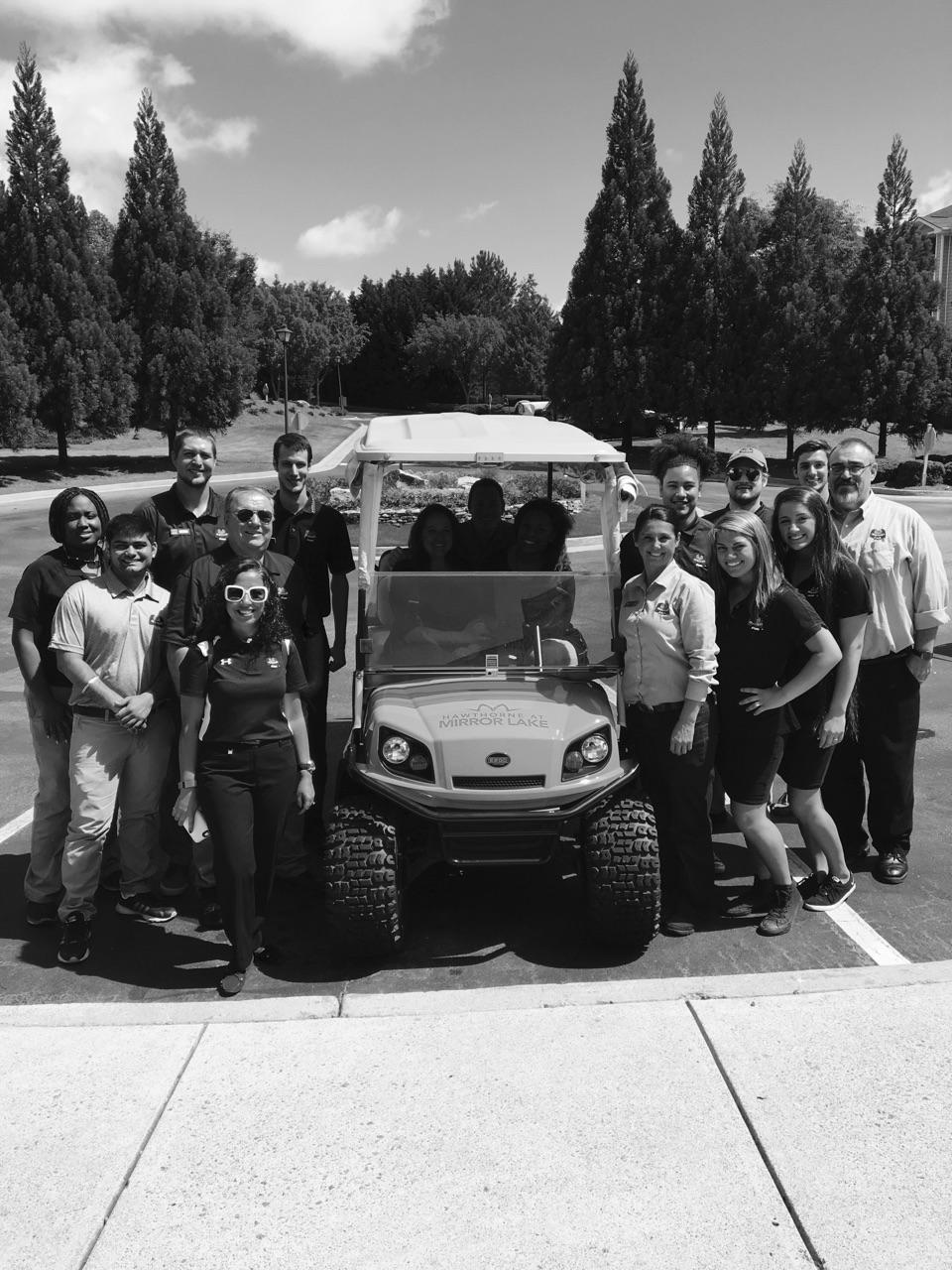 Local store marketing team gathered around a golf cart at a Villa Rica apartment community
