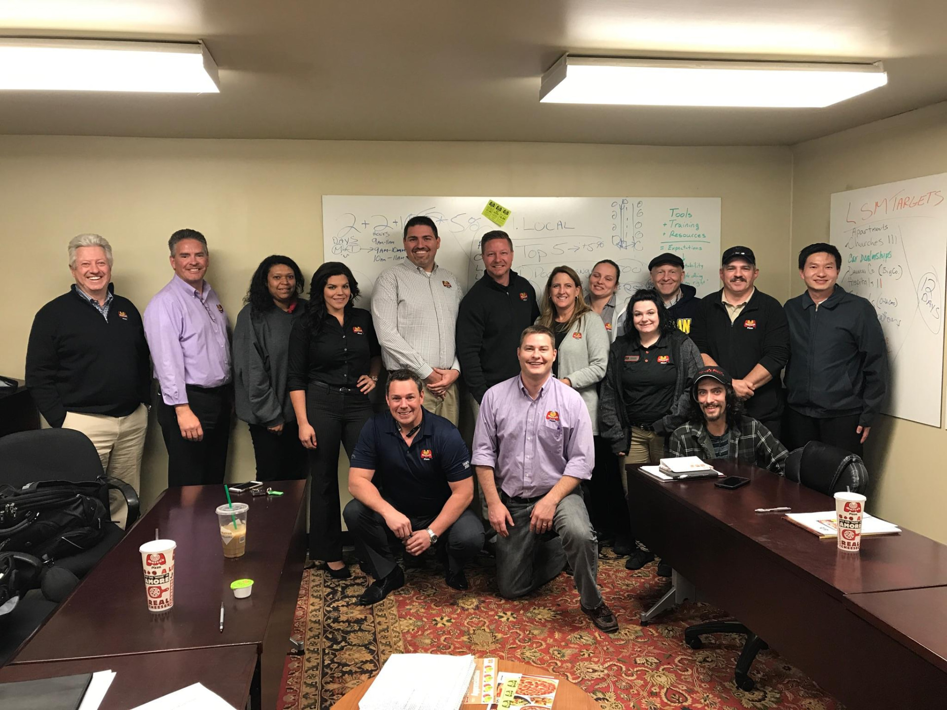 Franchise team in front of an LSM targets whiteboard after a planning session