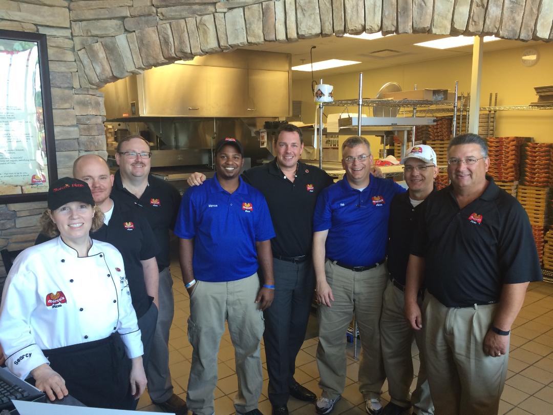 Marco's Pizza store team gathered in the kitchen before a route
